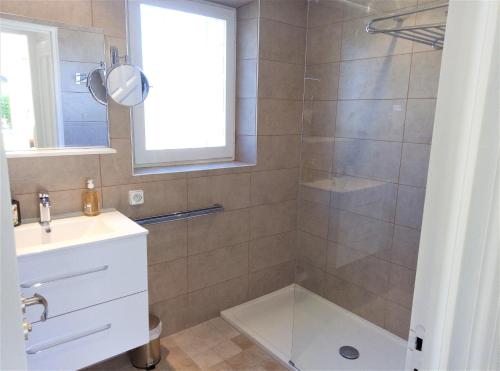 ein Bad mit einer Dusche, einem Waschbecken und einem Spiegel in der Unterkunft Appartement 10 en duplex - LES SUITES DE ROBINSON - Résidence avec piscine en bord de Siagne, à Mandelieu-La-Napoule in Mandelieu-la-Napoule
