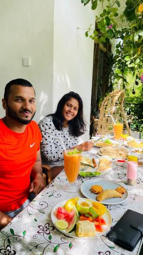 a man and a woman sitting at a table with food at The kingdom of ella in Ella