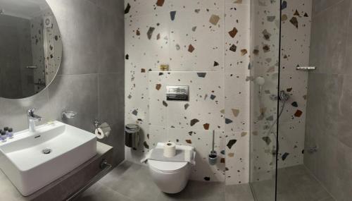 uma casa de banho com um chuveiro, um WC e um lavatório. em Ellas Hotel em Skala Potamias