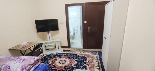 a bedroom with a bed and a television and a desk at SMD Comfy Apartments in Abu Dhabi