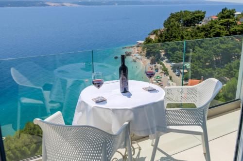 una mesa con copas de vino y vistas al océano en Deluxe Villa KENNEDY, en Mimice