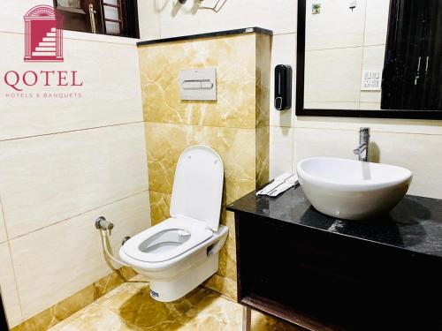 a bathroom with a toilet and a sink at Qotel Hotel Rajouri Garden Above Ritu Marbles, Near Rajouri Garden Metro Station-Couple Friendly in New Delhi