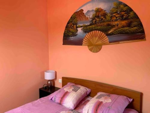 um quarto com uma cama com um quadro na parede em Appartement - Plogoff Pointe du Raz em Plogoff