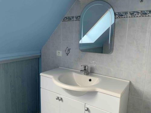 a bathroom with a sink and a mirror on the wall at Appartement - Plogoff Pointe du Raz in Plogoff