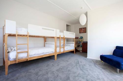 a bedroom with two bunk beds and a blue couch at Harbour View Motel in Robe