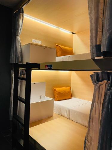 a room with two bunk beds and a ladder at Rabbitel Phuket in Phuket