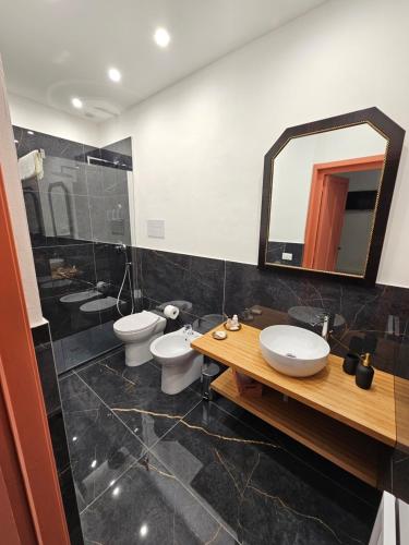 a bathroom with three toilets and a mirror at Lu Màri case vacanze in Balestrate