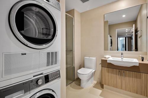 a bathroom with a washing machine and a sink at Quest East Perth in Perth