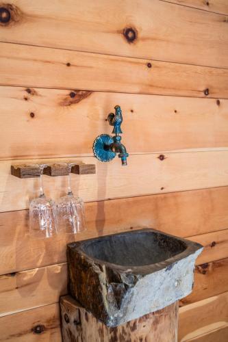a wooden wall with a sink and wine glasses at Wuidererhüttn, Charlet in Alleinlage mit freistehendem Saunahaus in Großkirchheim