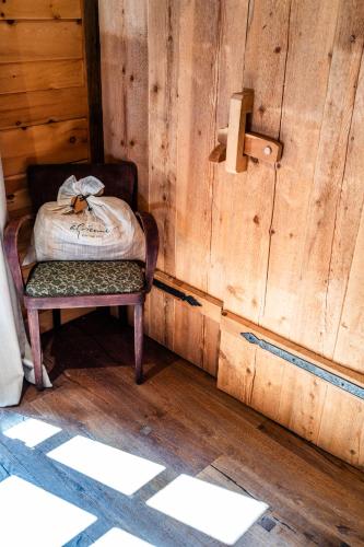 a room with a chair in a wooden wall at Wuidererhüttn, Charlet in Alleinlage mit freistehendem Saunahaus in Großkirchheim