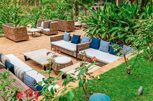 a patio with couches and tables in a garden at Gran Melia Arusha in Arusha