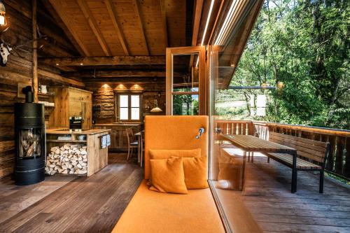 a porch of a cabin with a bench and a stove at Wuidererhüttn, Charlet in Alleinlage mit freistehendem Saunahaus in Großkirchheim
