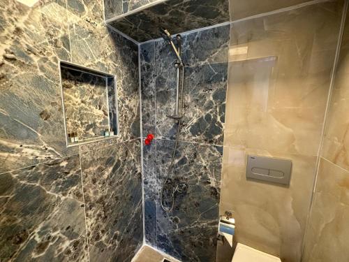 a bathroom with a shower with a glass door at st945 Palas Otel in İzmir