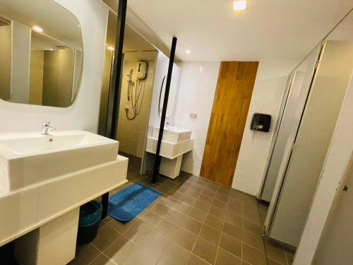 a bathroom with a sink and a mirror and a shower at Rabbitel Phuket in Phuket Town