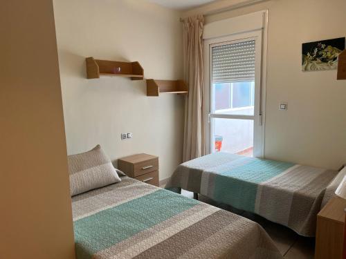 Duas camas num quarto com uma janela em Fuengirola Centro Marconi em Fuengirola