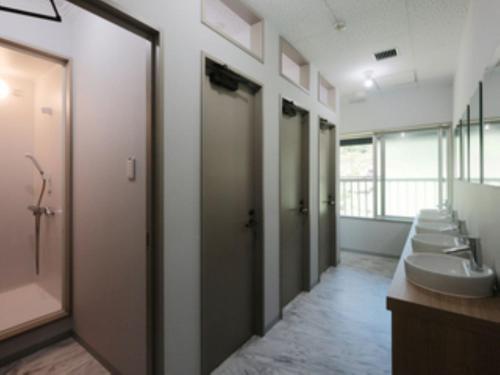 a bathroom with four sinks and a row of toilets at 松代棚田ハウス 