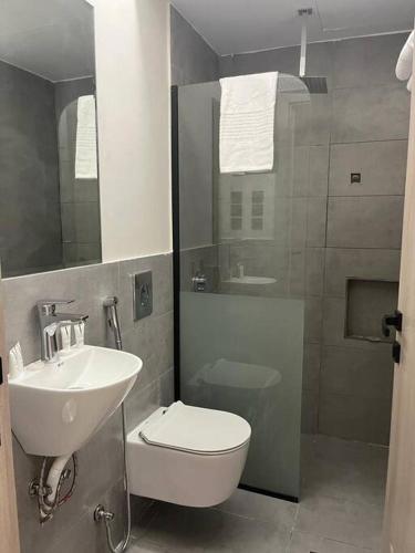a bathroom with a sink and a toilet and a shower at فيلا ساره in Medina
