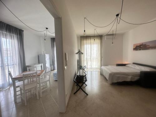 a bedroom with a bed and a table and a dining room at Domus Angela in Polignano a Mare