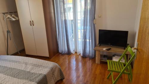 1 dormitorio con 1 cama y mesa con TV en Apartments Luna, en Sveti Filip i Jakov