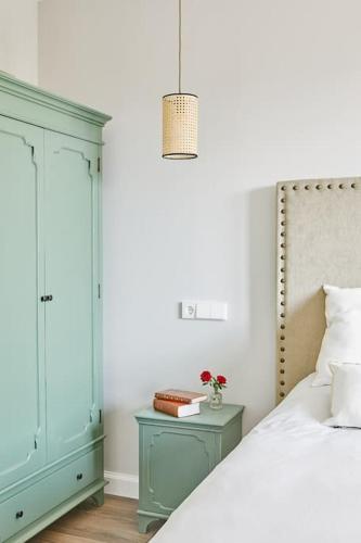 a bedroom with a bed and a dresser and a lamp at El Lagar de Luarca in Luarca