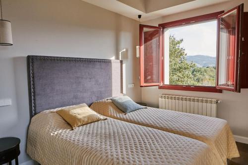 a bedroom with two beds and a window at El Lagar de Luarca in Luarca