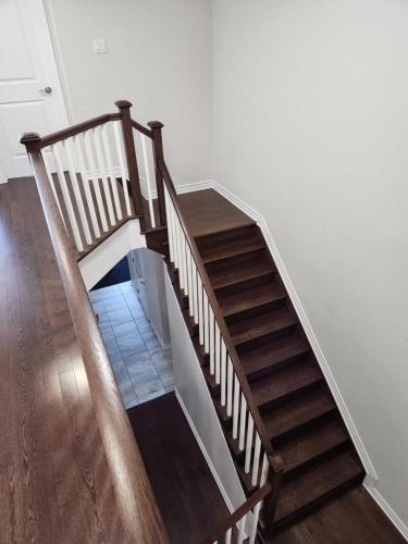 a stairway with a wooden railing and a wooden floor at Stay with Star in Ottawa