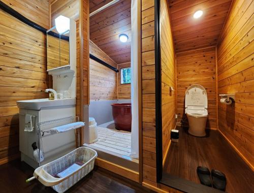 Habitación de madera con baño con aseo. en リバティーリゾート久能山 