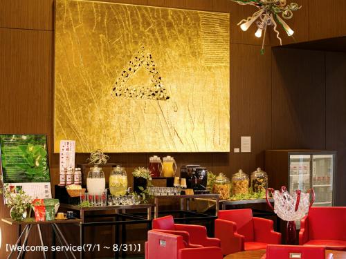 a restaurant with red chairs and a large painting on the wall at Oriental Hotel Hiroshima in Hiroshima