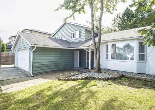 a white house with a tree in the yard at New Master room & private washroom 203 in Richmond