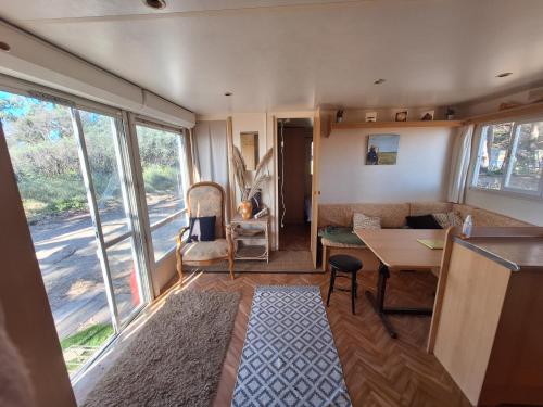 Cette caravane comprend un salon avec une table et un canapé. dans l'établissement Mobil-home on the beach, à Lucciana