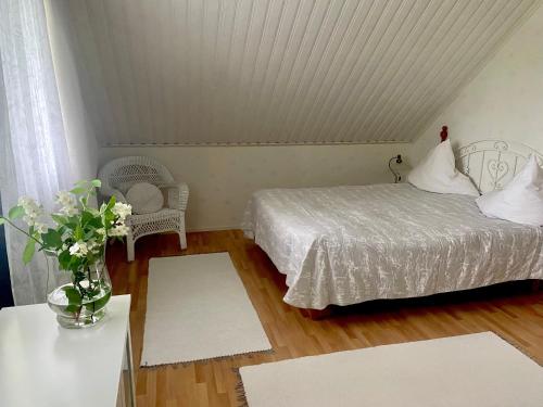 a bedroom with a bed and a table with a vase of flowers at Villa Grinberg in Mäntyharju