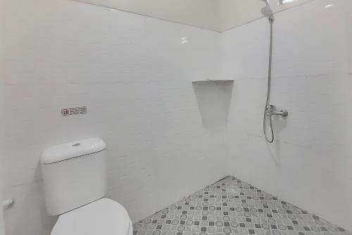 ein weißes Bad mit einer Dusche und einem WC in der Unterkunft Urbanview Hotel MM Indramayu by RedDoorz in Indramayu