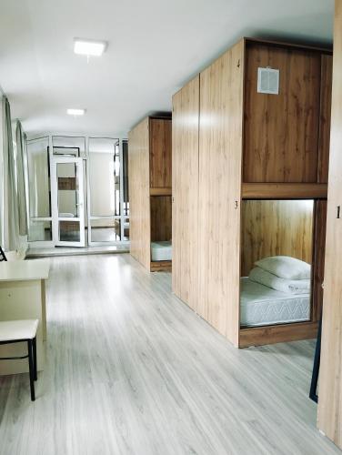 Zimmer mit Etagenbetten und einem Schreibtisch in der Unterkunft Salma Capsule Hostel in Bischkek