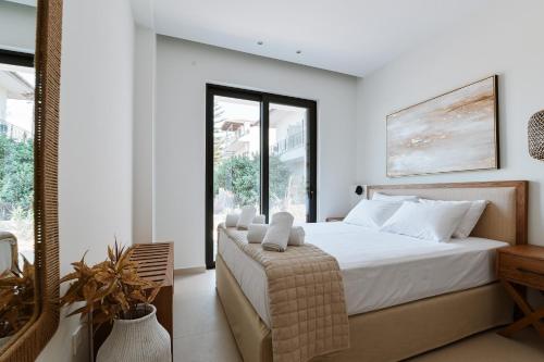 a bedroom with a bed and a large window at Melior Luxury Villas in Mitikas