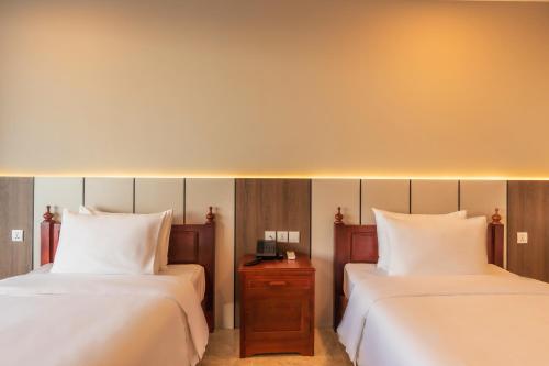 a hotel room with two beds with white sheets at Otres Beach Hotel in Sihanoukville