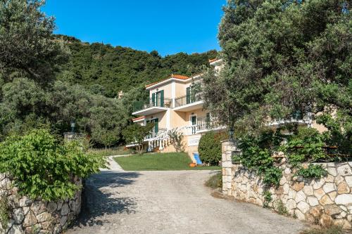 a house with a stone wall and a driveway at Anemona studio G in Katelios