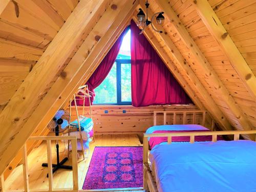 a attic bedroom with two beds and a window at İnziva Bungalow1 in Ardeşen