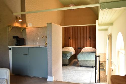 a kitchen with two beds in a room at Kerkhotel Bij De Pastorie in Reitsum