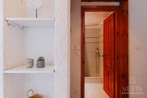 La salle de bains est pourvue d'une porte rouge et d'un mur blanc. dans l'établissement Amphitriti SeaFront Apartments, Loutra Agia Paraskevi, à Agia Paraskevi
