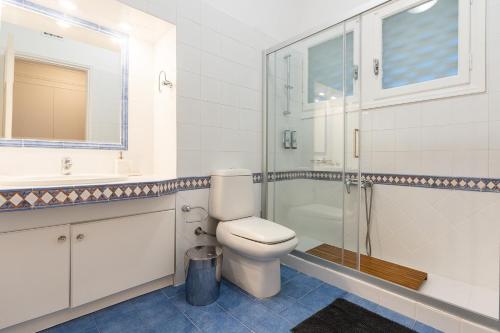 a bathroom with a toilet and a sink and a shower at Villa Antiope Saronida in Saronida