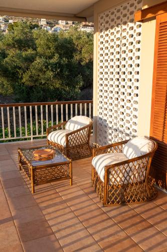 two wicker chairs and a table on a patio at Villa Antiope Saronida in Saronida