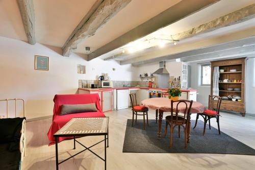une cuisine et un salon avec une table et des chaises dans l'établissement Gîte Romy - Gîte avec piscine partagée, à Lussan