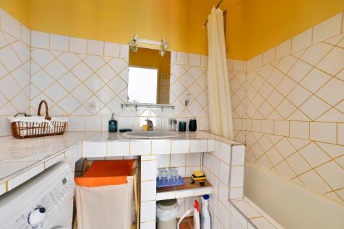 a bathroom with a sink and a tub at Gîte Pina - Gîte avec piscine partagée in Lussan