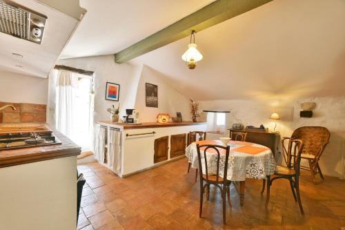 une cuisine avec une table et des chaises ainsi qu'une cuisine avec une cuisinière dans l'établissement Gîte Pina - Gîte avec piscine partagée, à Lussan
