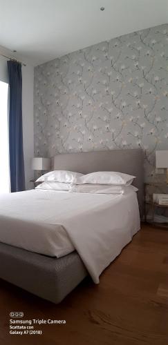 sypialnia z dużym białym łóżkiem z zagłówkiem w obiekcie Piazza Venezia Suite and Terrace w Rzymie