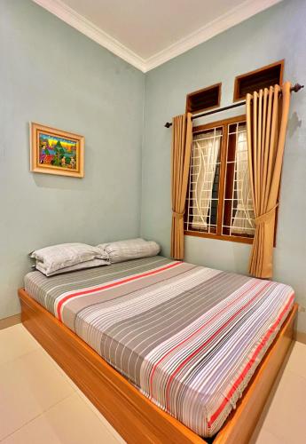 1 dormitorio con cama y ventana en Vila Kusuma Estate Batu, en Batu