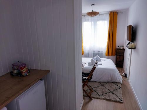 a bedroom with a bed and a window with yellow curtains at Le Sympathique - Petit Déjeuner, Netflix, Jacuzzi in Rouen