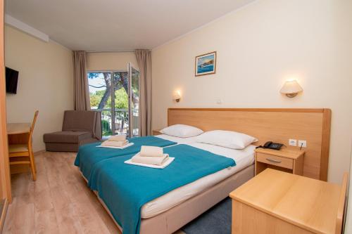 1 dormitorio con cama, escritorio y silla en Centinera Resort, en Pula