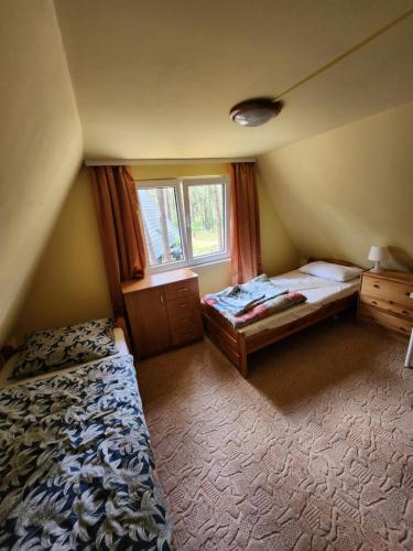 a small bedroom with a bed and a window at Jak Tu Sielsko in Osiek