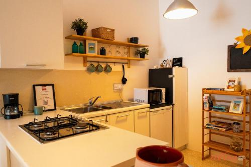 een keuken met een fornuis, een wastafel en een koelkast bij A magical getaway by the sea in Marsalforn